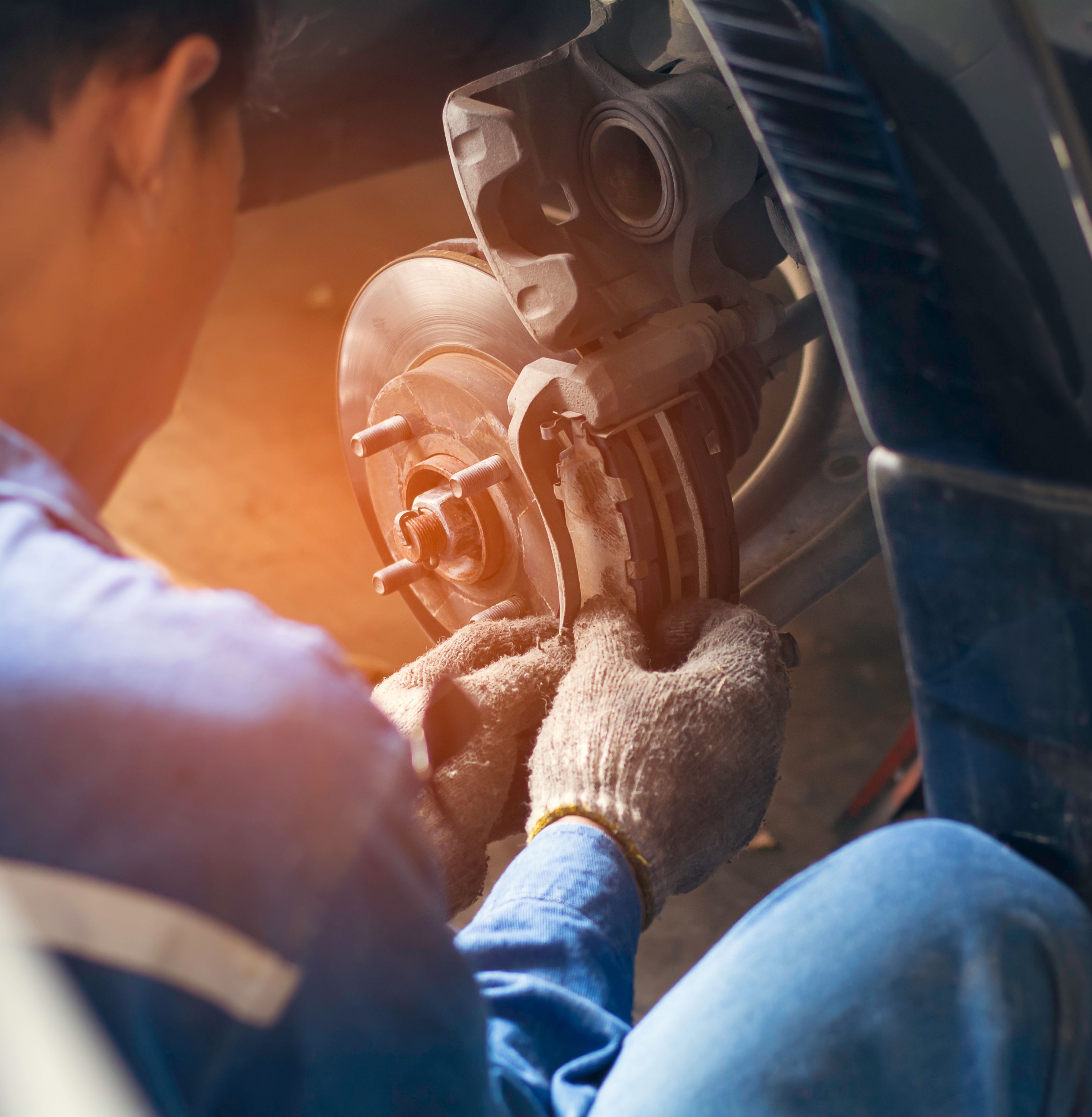 Mechanic installing brake caliper on rotor